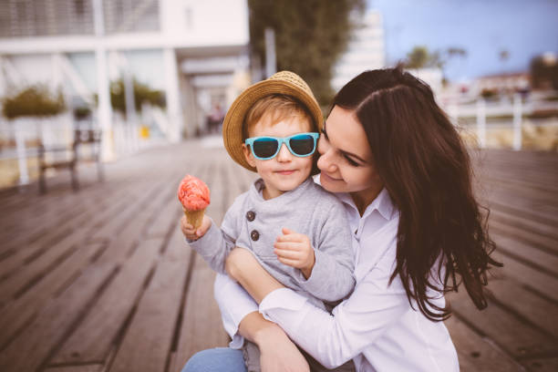 istock Young single mum hugging cute son who eats ice cream 649163882