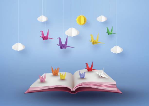 origami gemacht farbiges papier vogel fliegt über offenes buch - origami stock-grafiken, -clipart, -cartoons und -symbole