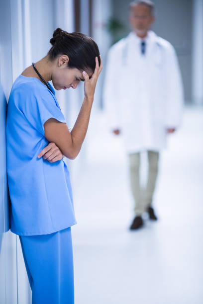 istock Depressed female surgeon leaning against wall 649176036
