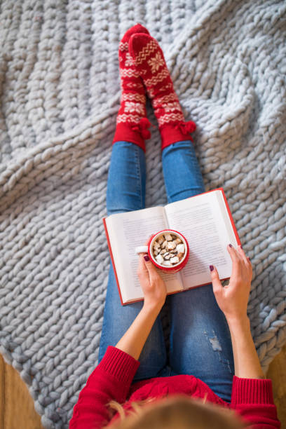 istock Woman reading book with hot drink 649184124