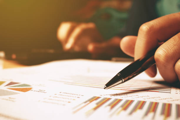 istock Close up of hand woman holding pen pointing on summary. 649188414