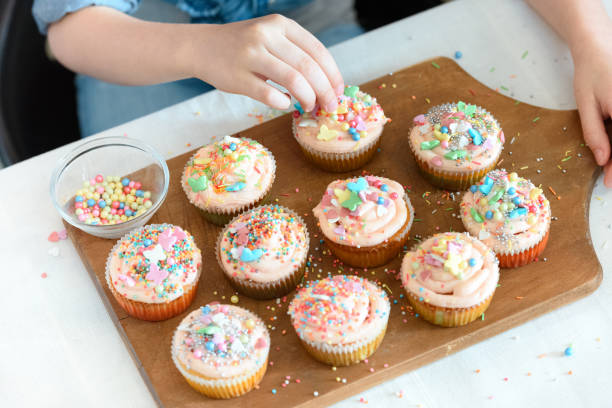 istock high angle view of girl decorating cupcakes on board 649188972