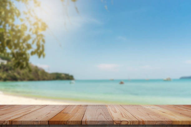 istock wood table top and blue sky with seascape background 649191208