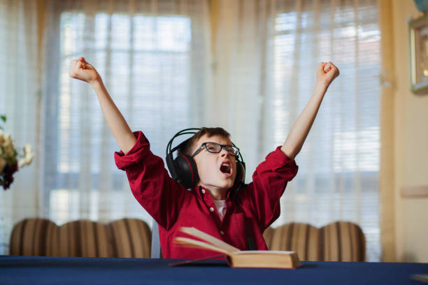 istock Cute boy listening and singing a song with emotions 649197850