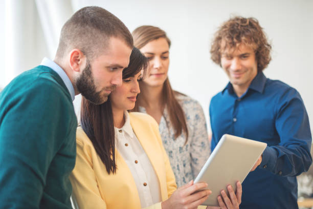 istock Professionals and young business people discussing tasks and finances in modern interior 649206028