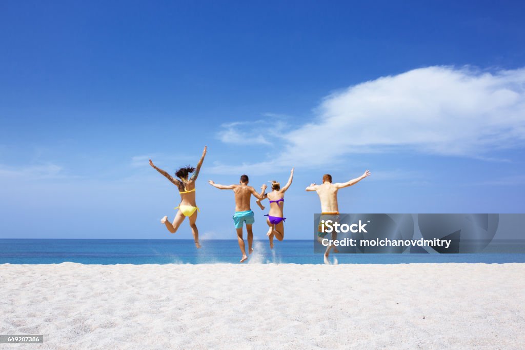 Happy friends on lonely beach Happy friends having fun on lonely tropical beach Beach Stock Photo