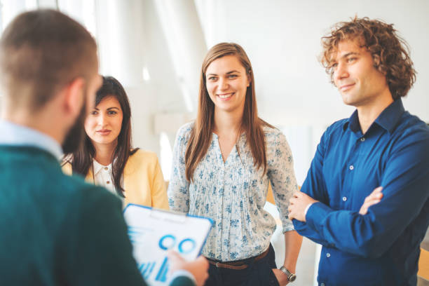istock Professionals and young business people discussing tasks and finances in modern interior 649207452