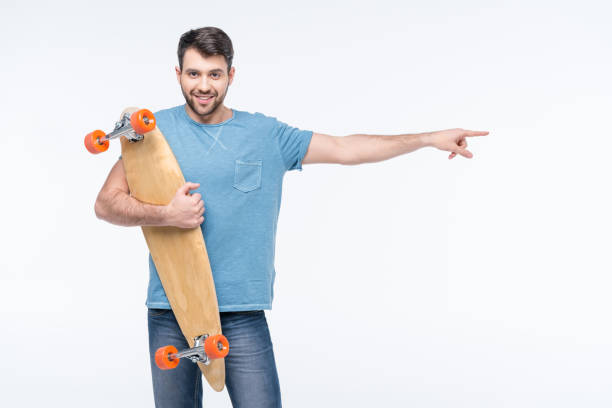 istock portrait of smiling man with skateboard pointing to right 649210962
