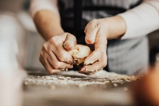 Photo of Close-up of woman's hands kneading dough
