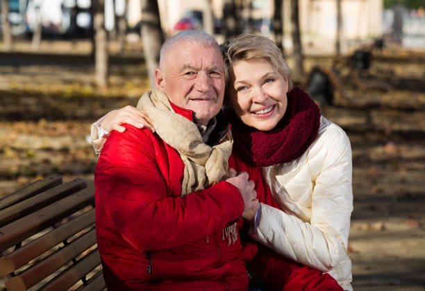 istock Mature couple sitting in park 649223992