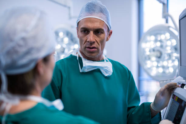 istock Surgeons discussing over medical reports in operation room 649229312