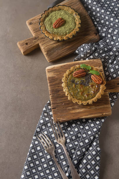 istock Green tea vegetarian pie match with nuts and mint. Dark background. Selective focus. Top view
