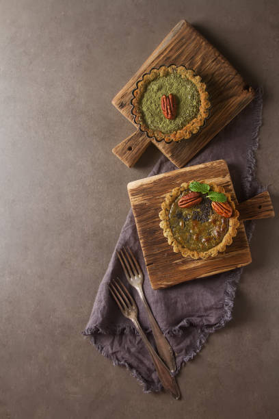 istock Green tea vegetarian pie match with nuts and mint. Dark background. Selective focus. Top view