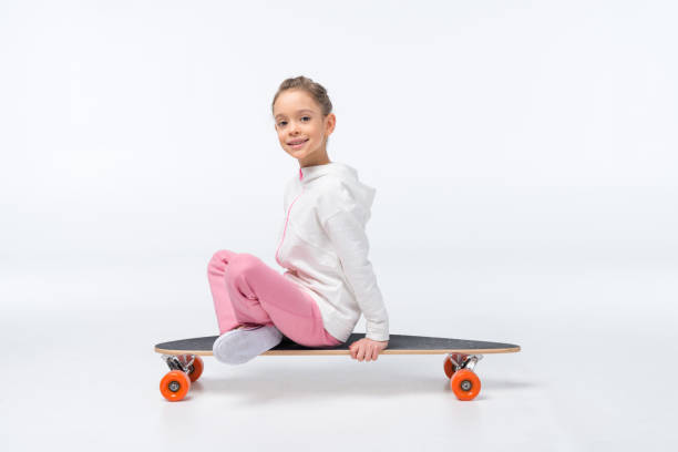 istock smiling girl sitting on skateboard on white 649232884