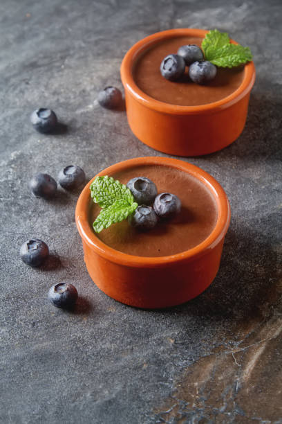 istock Chocolate mousse with berries in a ceramic bowl. Grey dark backg 649236294
