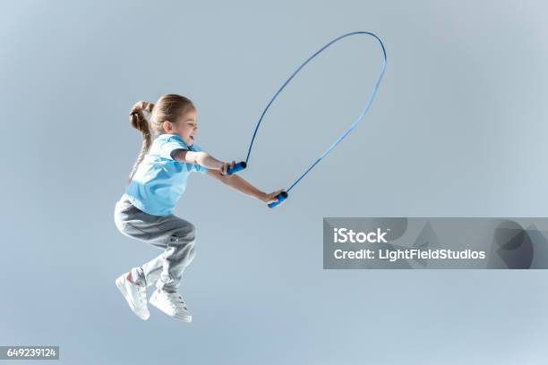 Happy Girl Humping Exercising With Skipping Rope On Grey Stock Photo - Download Image Now
