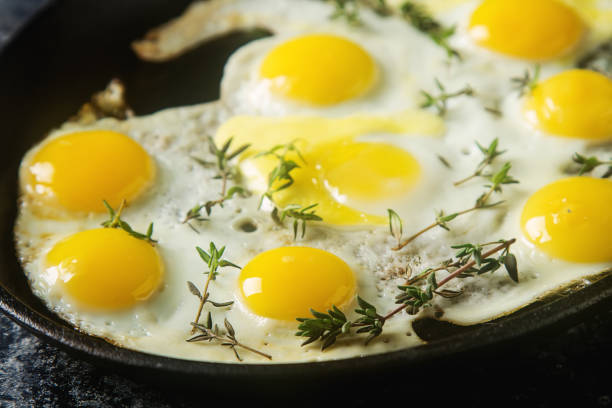 istock Fried quail eggs in a frying pan with thyme. Dark background. 649239428