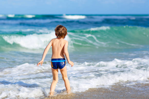 istock little blond kid boy having fun on ocean beach in Florida 649240524