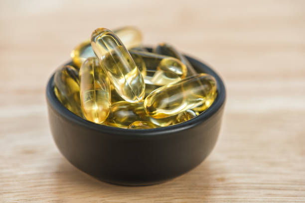 대구 간 오일 오메가 3 젤 캡슐 에 그릇 에 바닥 나무 - vitamin e cod liver oil vitamin pill capsule 뉴스 사진 이미지
