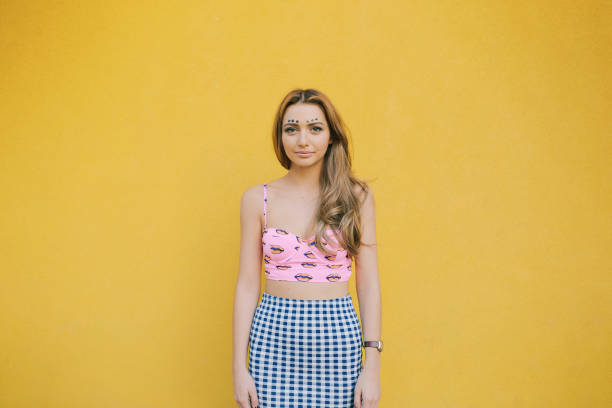 Retro-styled toned portrait of young attractive woman standing in columns passage with arms crossed.