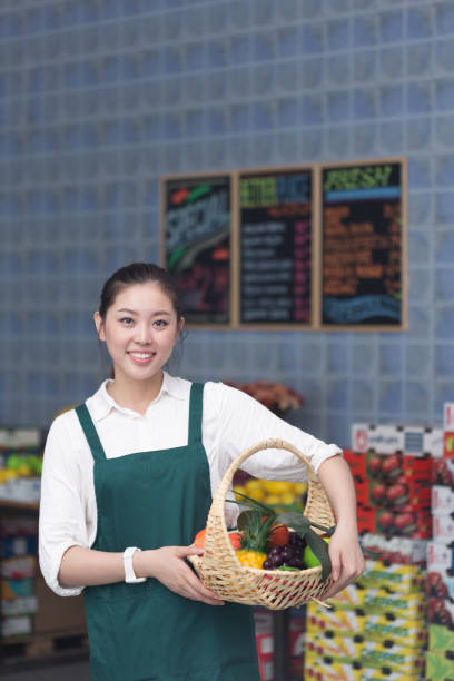 istock young pretty woman works in fruit store 649252654