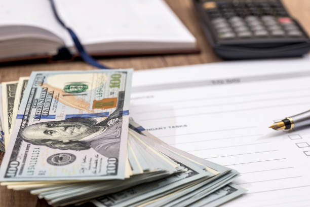 istock dollars and calculator with blank sheet on the table 649256608