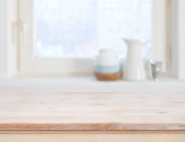 mesa de madera superior sobre fondo de ventana de cocina borrosa - focus on foreground selective focus focus household equipment fotografías e imágenes de stock