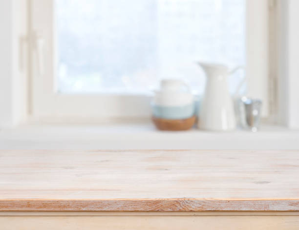 Wooden table top on blurred kitchen window background