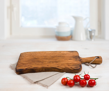 Cutting board above linen tablecloth on wooden table. Cooking concept