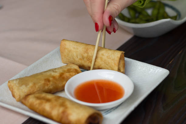 istock Woman hand taking spring roll with a chopstick 649268148