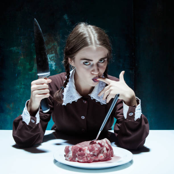 tema de halloween sangrienta: muchacha loca con un cuchillo, el tenedor y la carne - blood human hand women murder fotografías e imágenes de stock