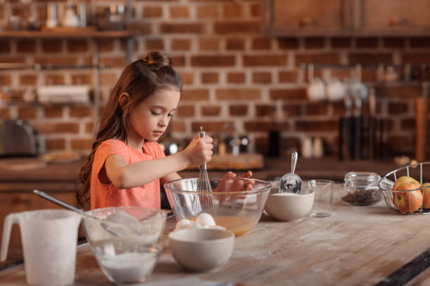 istock 'focused girl mixing ingredients for dough for cake 649273810