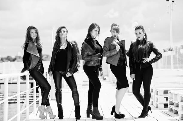 istock Five beautiful young girls models at leather jackets posing on berth. 649281290