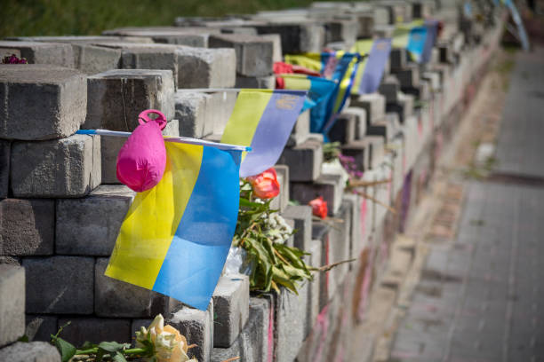 mémorial érigé pour les personnes tuées par les tireurs d’élite sur heroyiv nebesnoyi sotni rue pendant la révolution de euromaidan et de manifestations sur la place maidan - place de l’indépendance avec un drapeau ukrainien là-dessus - civil war photos et images de collection