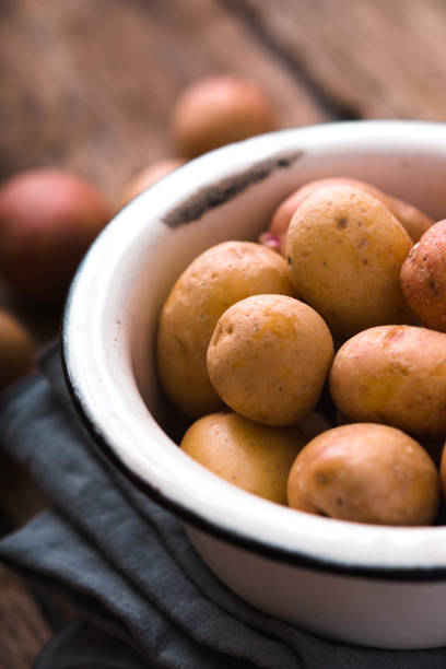 istock Raw potatoes in the metal bowl vertical 649302120