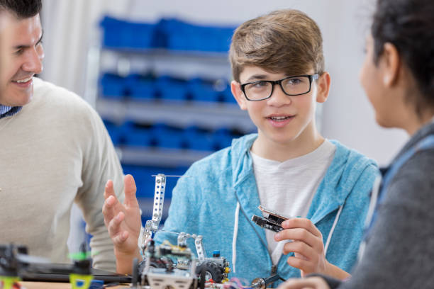 istock High school technology teacher works with students in class 649303178