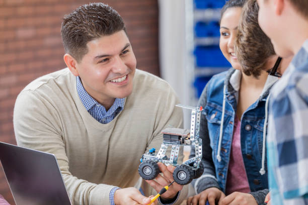 istock Cheerful Hispanic high school technology teacher with students 649303196