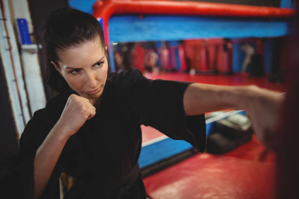 istock Female karate player practicing boxing with punching bag 649308298