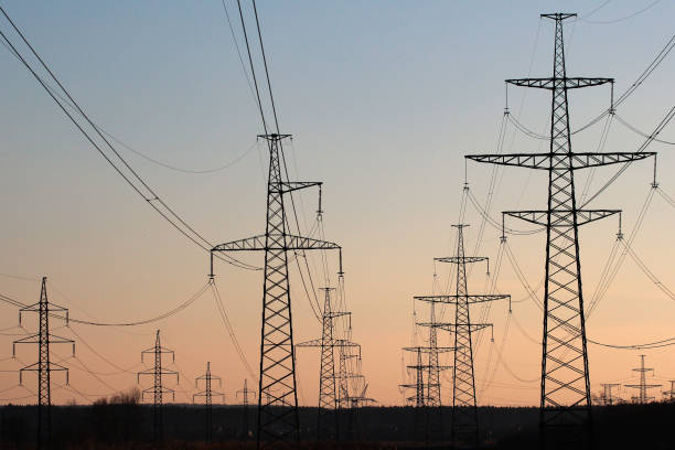 istock Power line pylons against sunset sky background 649308636