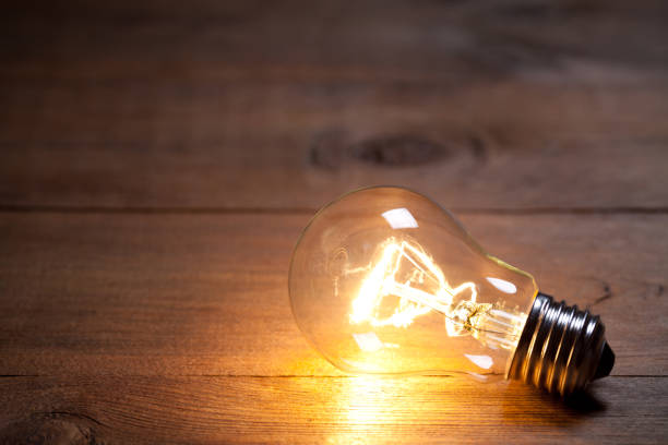 istock Vintage incandescent bulb on old wooden table 649309914