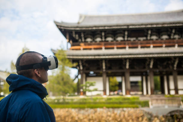 uomo che usa cuffie per la realtà virtuale in un tempio giapponese - shinto japan temple nature foto e immagini stock