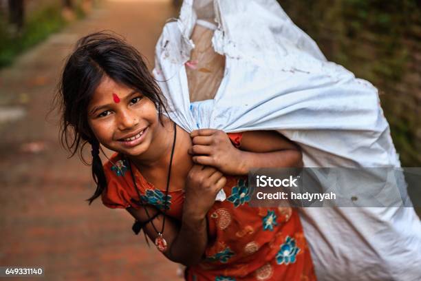 Poor Indian Girl Collecting Plastic Bottles For Recycling Stock Photo - Download Image Now