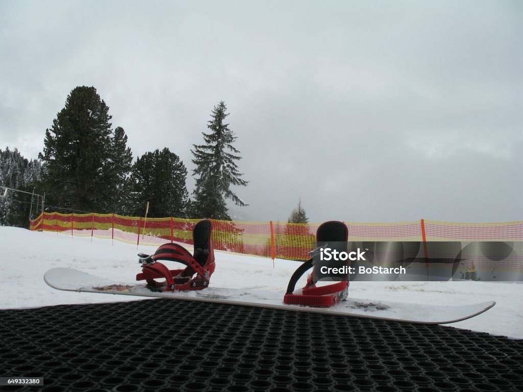Snowboard with bindings put on step with snow mountain view Snowboard ready to put in  mountain ski area. Austria Stock Photo