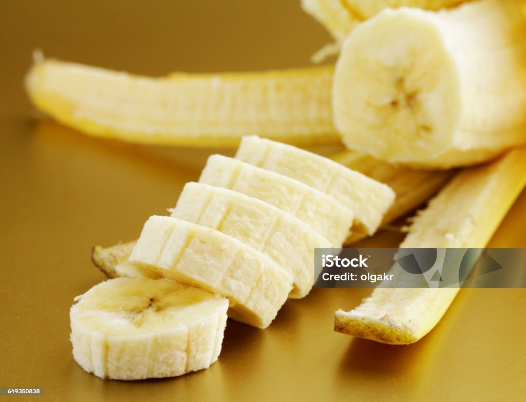 ripe organic banana sliced on a gold background Banana Stock Photo