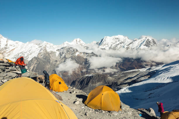 High Altitude Camp of Mountain Expedition Orange Tents of high Altitude Camp of Mountain Climbers Expedition in Himalaya Nepal in the evening base camp stock pictures, royalty-free photos & images