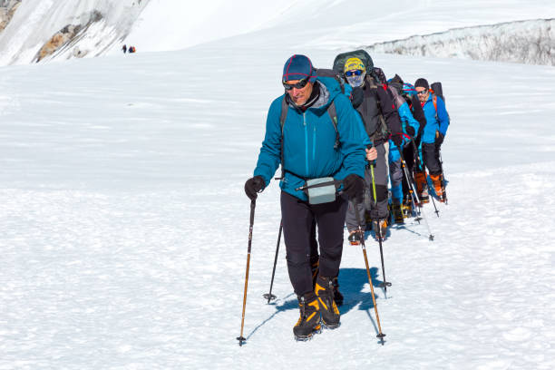 istock Mature Guide leading Group of Mountain Climbers on Glacier 649355222