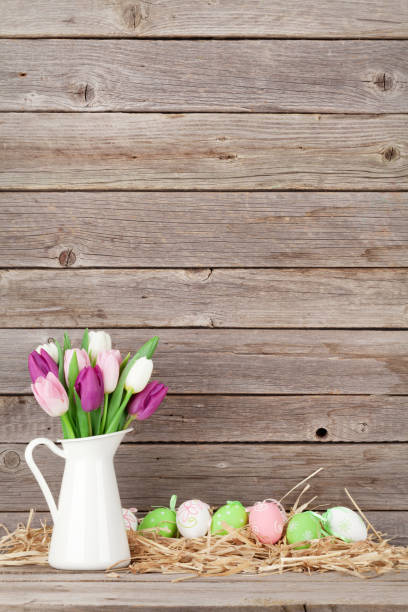istock Easter eggs and colorful tulips bouquet 649355314