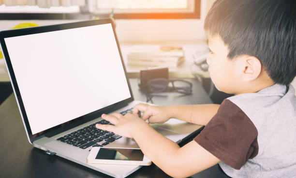 istock Asian kid is using a laptop with Blank screen for mock up 649355458