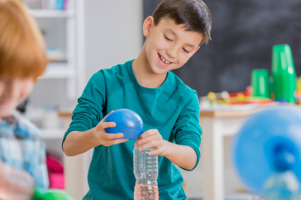 istock Confident mixed race schoolboy prepares for science experiment 649355460