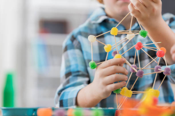 junge schafft etwas aus zahnstochern und gum drop süßigkeiten - science education child classroom stock-fotos und bilder